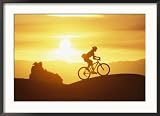 A Woman Rides Her Bike in the Sunset with Rock Cliffs in the Background Framed Photographic Poster Print by Dugald Bremner, 35x26