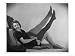Smiling Young Woman Reclining on Tasselled Cushions Pulls on a Wool Stocking Art Gicl...