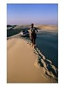 Woman Walking Towards Car on Sand Dune Ridge, Khor Al-Adaid, Qatar Photographic Poster Print by Mark Daffey, 30x40