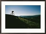 A bicyclist rides along the ridge of a mountain Sports Framed Art Poster Print by Skip Brown, 29x21