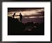 A Man with a Camera Helps a Woman Down Rocks Near Tanah Lot Temple Framed Art Poster Print by Eightfish, 22x18