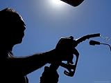 An Employee of a Petrol Station Holds a Petrol Pump after Filling up a Car Photographic Poster Print, 24x18
