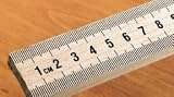 Meter stick; Maple wood; Scaled in millimeters on one side and inches on the other; With metal ends