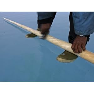 A hunter cleans a narwhal tusk in a melt water pond on the sea ice Stretched Canvas Poster Print by Paul Nicklen, 24x18