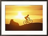 A Woman Rides Her Bike in the Sunset with Rock Cliffs in the Background Framed Photographic Poster Print by Dugald Bremner, 29x21