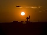 IMAGE OF UH-60 Blackhawk Flies over Camp Speicher Airfield at Sunset Stretched Canvas Poster Print by Stocktrek Images , 18x24