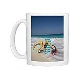 Two mismatched beach flip-flops with red sunglasses in the surf on a Caribbean Photo Mugs