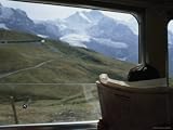 Passenger Reads on a Train Through the Highest Swiss Alps Photographic Poster Print, 24x18