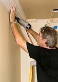 Carpenter Installing Crown Moulding in a Home Renovation - 24