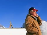 A Farmer Wearing a Baseball Cap Talks on a Cell Phone Photographic Poster Print, 24x18
