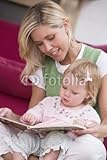 IMAGE OF Wallmonkeys Peel and Stick Wall Decals - Mother in Living Room Reading Book with Baby Smiling - 48