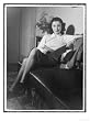 An Elegant Young Woman Reads Whilst Sitting on a Settee at Home Photography Giclee Poster Print, 18x24