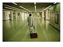 An Exhausted Traveler Drags His Bag Through Bangkoks Airport Photographic Poster Print by Eightfish, 24x18