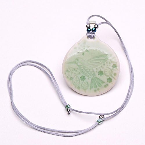 True porcelain pendant with a hummingbird in the mountains motif. The pendant is about 1.75 in. or 4.5 cm.in dia., lanyard is adjustable, about 26 in. total length.