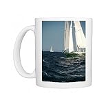 A beautiful green and gold colour yacht cuts through the waves in the evening Photo Mugs