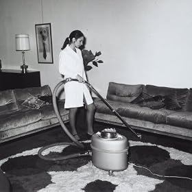 Young Woman Using a Vacuum Cleaner on a Carpet in a Lounge Photographic Poster Print by A. Villani, 24x24