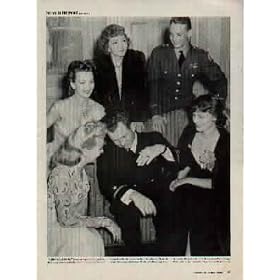 HEROES IN HOLLYWOOD: "Sighted sub, sank same" is famous report of Ensign Donald Mason, demonstrating how he dived his plane and dropped two bombs on a submarine in the Atlantic. Clustered around him counterclockwise: CLAUDETTE COLBERT, CAROLE LANDIS, BETTY GRABLE, RUTH HUSSEY and GEORGE WELCH, Medal of Honor Nominee who brought down four Jap planes at Pearl Harbor. ..... 1942 LIFE Magazine Picture, A4457A.