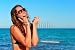 Wallmonkeys Peel and Stick Wall Decals - Young Smiling Woman Talking by Phone on a Beach - Removable Graphic