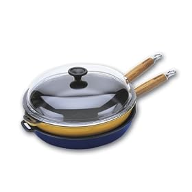 World Cuisine 11 inch diameter cast-iron frying pan with wooden handle. The pan's interior is black with an exterior of green.