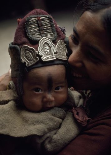 A baby wears a protective woolen cap adorned with amulets and needles Art Print Poster
