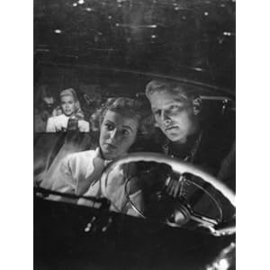 Young Couple Snuggling in Convertible as They Intently Watch Movie at Drive-in Movie Theater Photographic Poster Print by J. R. Eyerman, 24x32