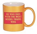 HE WHO DIES WITH THE MOST MODEL TRAINS WINS Coffee Mug in Metallic Colors