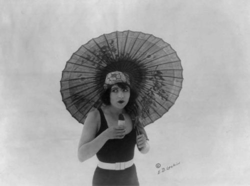 1922 Betty Compson, half length portrait, standing, with umbrella, in bathing suit, facing slightly