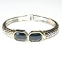 Silver Tone Bangle Bracelet With Gold Colored Trim Around Stone (UBB-029)