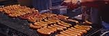IMAGE OF Man's Hand Cooking Hot Dogs on a Barbecue Grill, Taste of Chicago, Chicago, Illinois, USA Premium Photographic Poster Print by Panoramic Images , 8x24