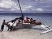 Teenage Boys Push a Grounded Outrigger Loaded with Girls Out to Sea Photographic Poster Print by W. Robert Moore, 12x16
