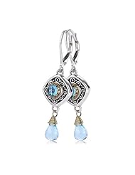 18KY & Sterling Silver These lovely sterling silver and 18k yellow gold Sara Blaine earrings feature a 4mm blue topaz focal stone and 2 faceted blue topaz accent stones.