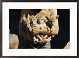 A man holds an armful of young coyotes Framed Art Poster Print by Walter Meayers Edwards, 29x21