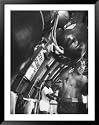 Boxer Rocky Marciano, Working Out Punching Bag, at Training Camp, Before Fight with Archie Moore Framed Art Poster Print by Grey Villet, 39x49