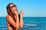 Young Smiling Woman Talking by Phone on a Beach - Peel and Stick Wall Decal by Wallmonkeys