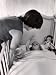 Jackie Kennedy Tucking Her Young Daughter Caroline Into Her Crib For an Afternoon Nap, at Home Photographic Poster Print by Alfred Eisenstaedt, 12x16