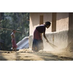 photographie A woman sweeps in front of her house in a Khasia Village at the fringe of Lowacherra...
