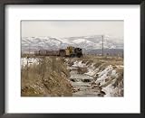A Train Follows Alongside a River Framed Art Poster Print by Taylor S. Kennedy, 22x18