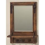 Western style mirror with stained frame and coat hooks.
