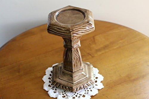 A tall, walnut colored, hexagon shaped ceramic candleholder.