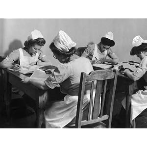 Four Young British Student Nurses Making Notes Together from Medical Textbooks Photographic Poster Print