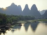 In Guilin Limestone Tower Hills Rise Steeply Above the Li River, Yangshuo, Guangxi Province, China Photographic Poster Print by Anthony Waltham, 12x9