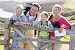 Wallmonkeys Peel and Stick Wall Decals - Family on Cliffside Path Leaning on Fence and Smiling - Removable Graphic