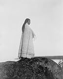 1913 photo Cowichan girl Cowichan woman, full-length portrait, wearing blanket, standing on rock.