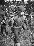 Determined Young Soldier Wearing a Helmet and Gunbelt and Carrying Equipment on His Shoulders Photographic Poster Print by George Strock, 12x16