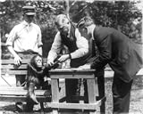 1922 Photo of Three men, one wearing badge, and orangutan at the National Zoo, Washington, D.C. Size