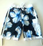 Mens "Tugger" Swim Trunks/Board Shorts with elastic waist, board short front, velcro fly and side flap pocket. Navy/White or Red/White. Fully lined. Sizes S-2XL.