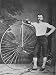 Cyclist Sporting Handlebar Moustache Posing Beside a High Wheel  Ordinary Bicycle Photographic Poster Print