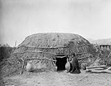 1907 photo Shows structure made of arrowbrush and earth, and woman seated by doorway. Pima ki (primi