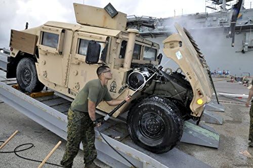 Marine uses a pressure washer to clean the underside of a Humvee hood. By: Stocktrek Images 24 x 30 Art Print