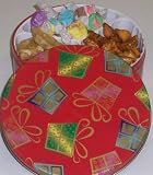 Scott's Cakes Taffy, Peanut Brittle, and Peanut Butter Pretzel Nuggets Combo in a Christmas Present Tin
